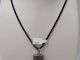 un collier noir et blanc orné d'un pendentif en forme de corne, monté sur une chaîne noire