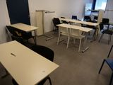 des tables et des chaises dans une pièce équipée d'un réfrigérateur et d'un réfrigérateur-congélateur