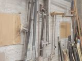 Plusieurs morceaux de bois sont empilés contre un mur dans un atelier.