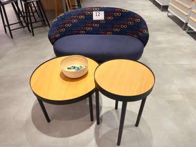 two tables and a couch in a store with a bowl of fruit on it