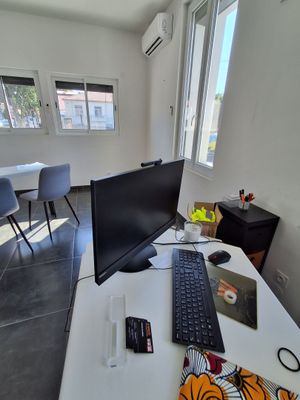 un bureau sur lequel se trouvent un ordinateur, un clavier, une souris et d'autres objets