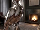 a silver bird statue sitting on top of a wooden table