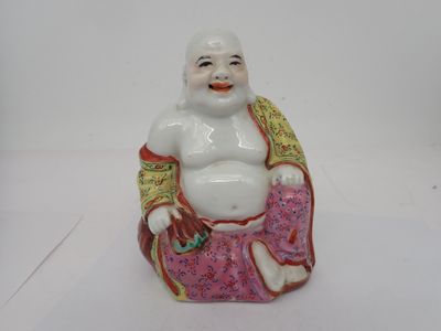 une figurine représentant un Bouddha souriant assis sur un coussin