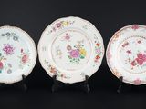 trois assiettes ornées de motifs floraux, posées sur une surface noire