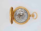 a close up of a gold pocket watch on a white surface