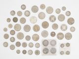 un assortiment de pièces d'argent posées sur une surface blanche, dans un sachet en plastique