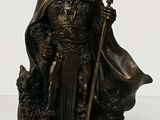 statue of a man with a horned head holding a staff and a dog