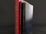 two books sitting on top of each other on a black surface
