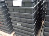 de nombreux bacs en plastique noir empilés sur une palette