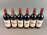 six bottles of red wine lined up in a row