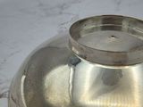 a silver bowl on a marble counter top