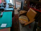 vue d'un salon avec un canapé, un fauteuil, une table et une bibliothèque