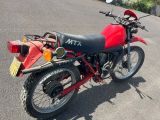 une moto rouge et noire garée sur le bord de la route