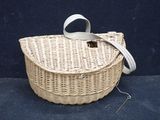 a wicker basket with a handle on a blue surface