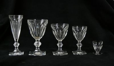 quatre verres à pied et un verre à vin sur fond noir