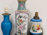 three vases and a lamp on a table