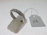 gros plan d'une bague sur une surface blanche avec une étiquette de prix