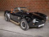 a black sports car parked in front of a brick wall
