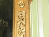 a mirror with a gold frame and a clock on the wall