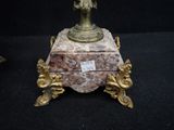 a gold and red vase sitting on top of a black table