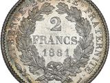 a silver coin with a wreath of leaves on it