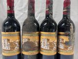 four bottles of wine are lined up in a row on a table