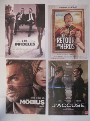 quatre affiches de cinéma accrochées au mur d'un immeuble, représentant un homme en smoking et une femme en robe