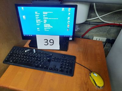 a computer monitor and keyboard on a desk with a price tag