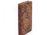 an old book that is sitting on a white surface