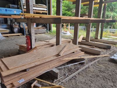 Dans un bâtiment, plusieurs morceaux de bois sont empilés les uns sur les autres.