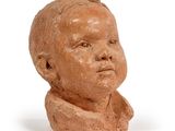 clay head of a young boy with a collared shirt on