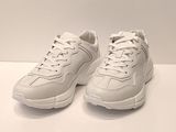 les baskets blanches sont posées sur une surface blanche, avec un fond blanc
