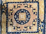 un gros plan sur un tapis jaune et bleu orné d'un motif en médaillon