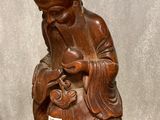 a wooden statue of a man holding a baby in his lap
