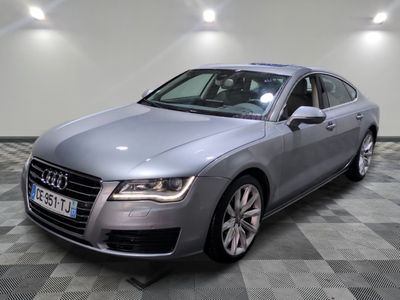 the audi is parked in a large room with a checkered floor