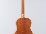 a wooden guitar hanging from a string on a wall