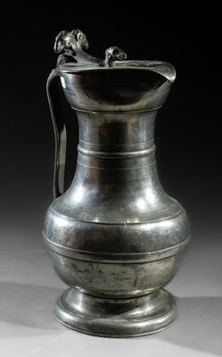 an image of a silver vase with a handle on a table