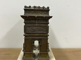 an image of a small statue of a gate on a wooden table