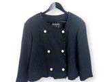 une veste noire à boutons dorés suspendue à un cintre