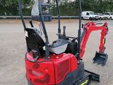 a small red excavator that is parked in a parking lot
