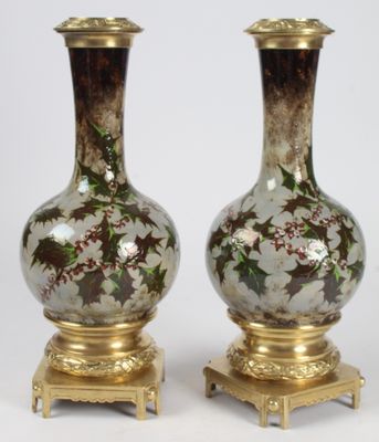 pair of vases with floral designs on gold bases on a white background