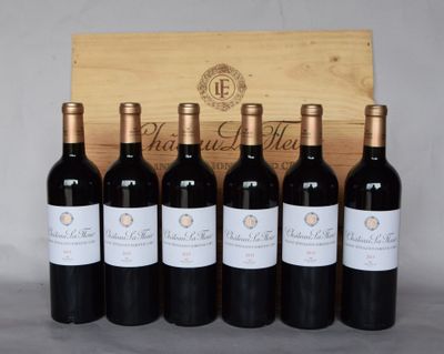 six bouteilles de vin rouge sont alignées devant une caisse en bois