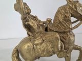 bronze statue of a man on a horse with a bird on its back
