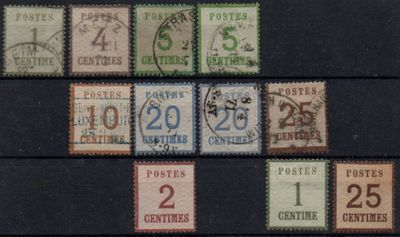several different postage stamps on a black surface with a number of them