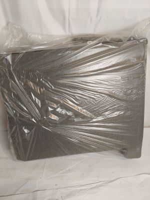 une boîte emballée dans du plastique posée sur une surface blanche