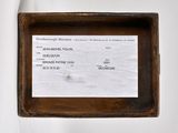 a small wooden box with a receipt in it