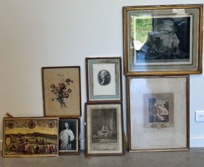 de nombreux tableaux encadrés accrochés au mur, à côté d'un chat