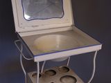 a small white table with a mirror on top of it