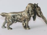 statue of a dog with a bone in its mouth on a white surface