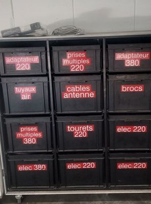 de nombreuses boîtes noires portant des chiffres rouges dans une pièce